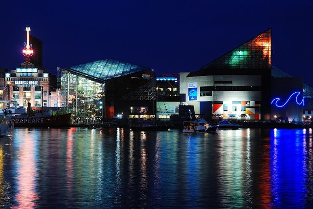 The lights of Baltimore Maryland are reflected in the waters of Inner Harbor