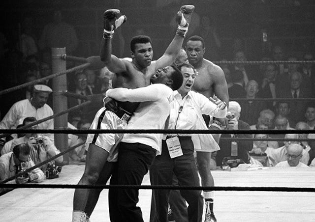 Boxer Muhammad Ali, triumphant, in black-and-white photo