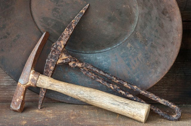 Gold pan equipment. Closeup of old picks, axe, and pan.