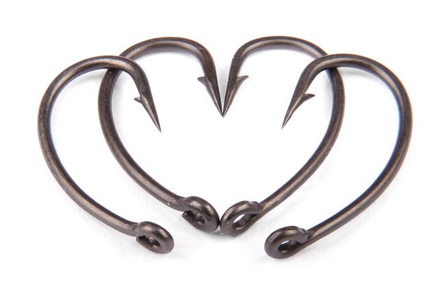 Four fishhook drawn up in heart shaped isolated on white backround.