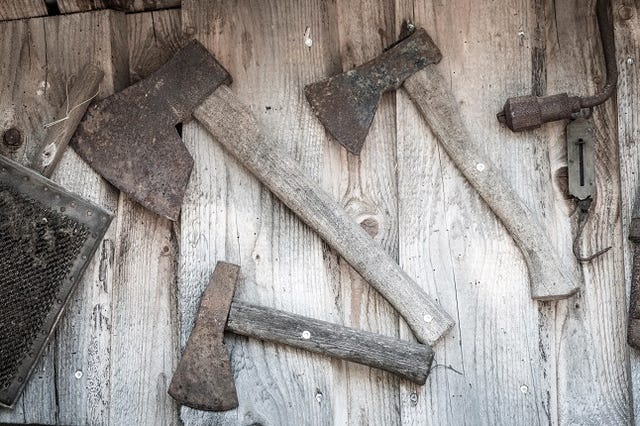 Old axes hanging on a wall in a wooden cabin