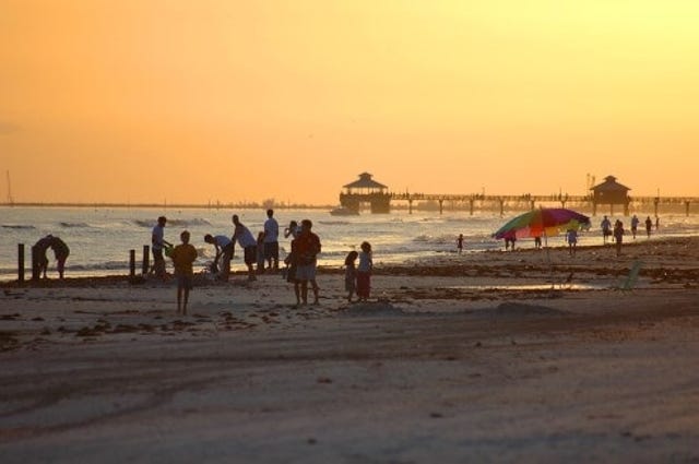 Sunset on a Fort Myers Florida beach with people on the sand