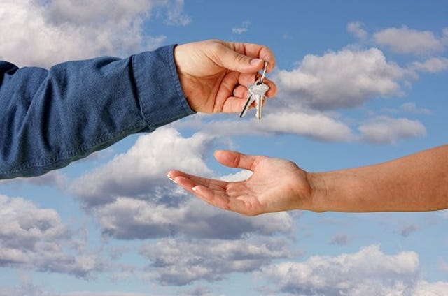 man handing keys over to a woman in sign of ownership