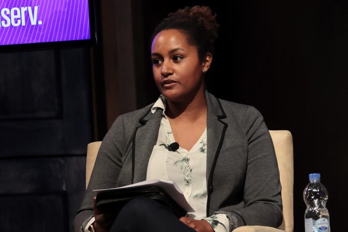 woman sitting on chair on conference stage; Kelly Fryer at New York Fintech Week