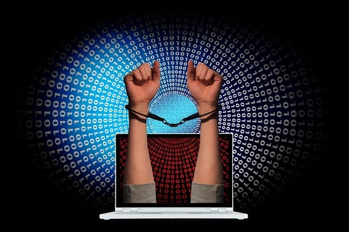 handcuffed arms coming up through a laptop